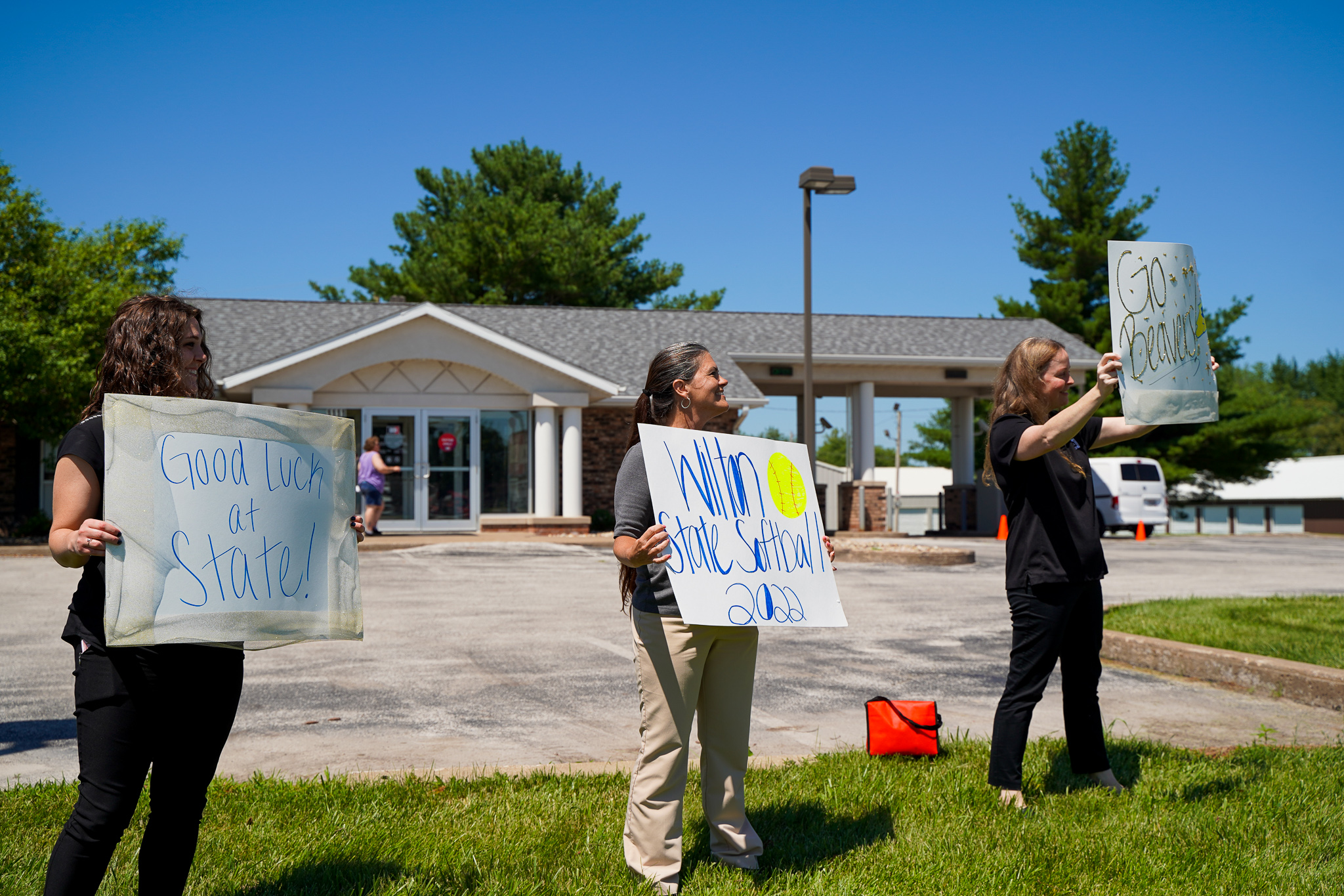 Employees hold signs for softball state sendoff