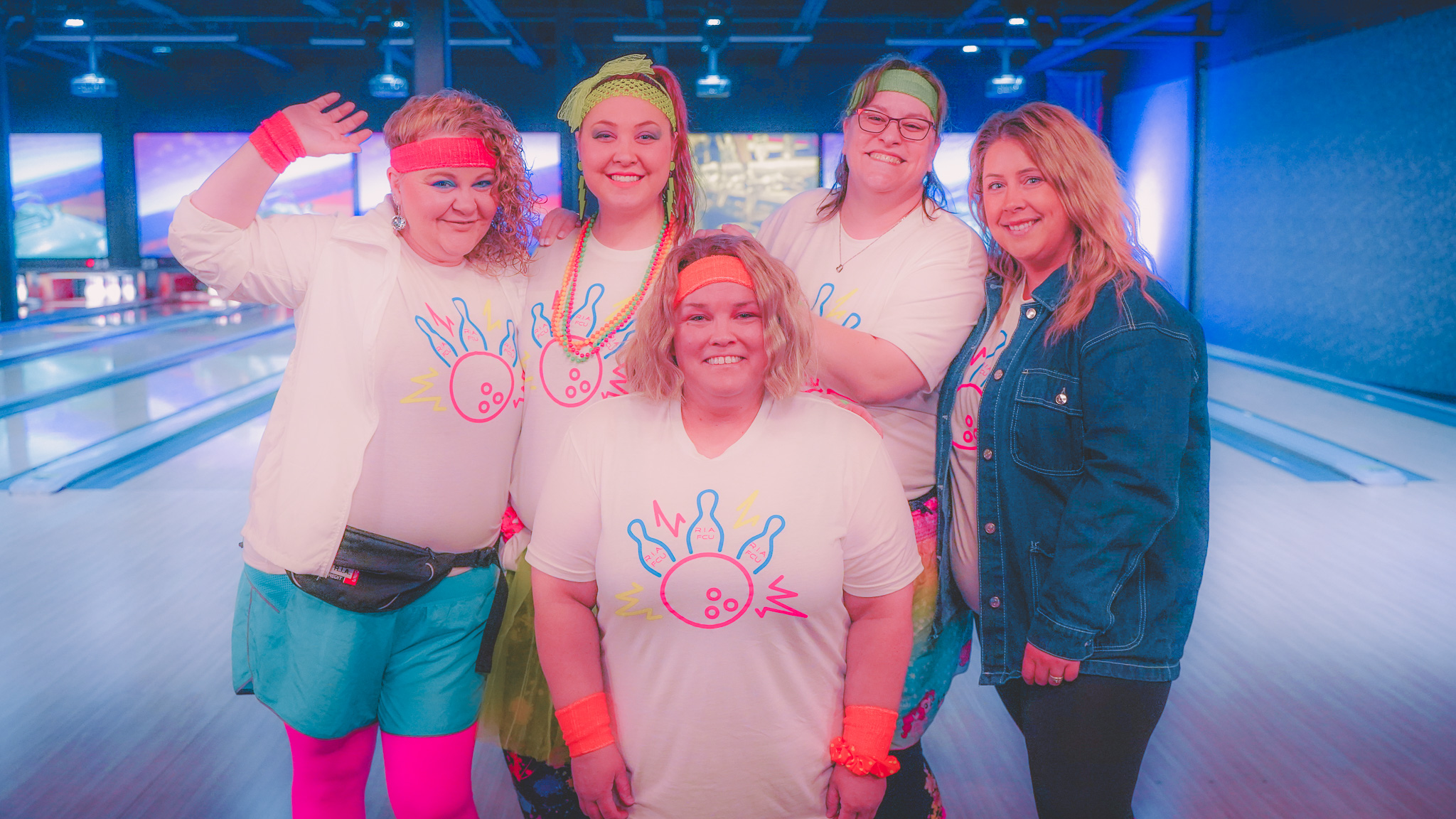 Group of employees dressed in an 80s theme at bowling alley