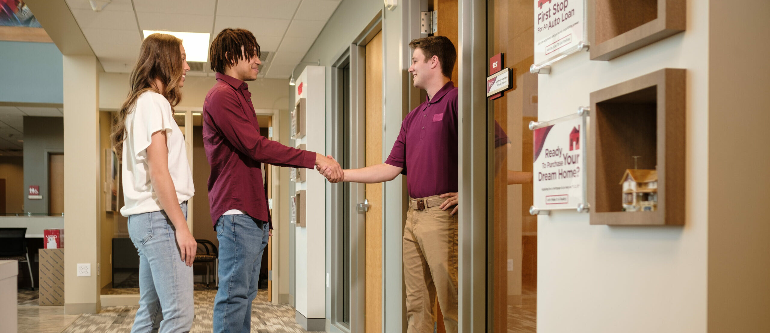 Young couple shaking hands with mortgage lender at R.I.A. 