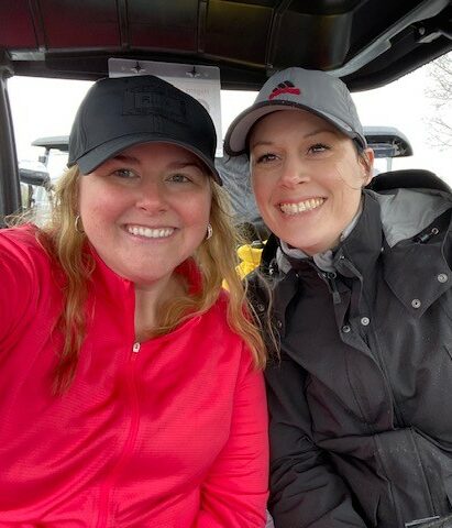 Two employees sitting in a golf cart